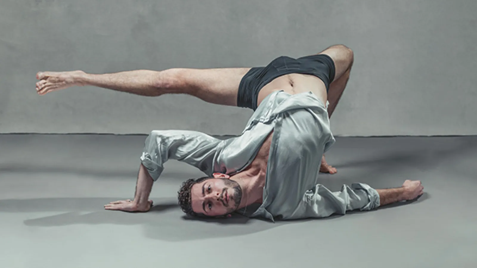 Dancer in gray shirt on floor