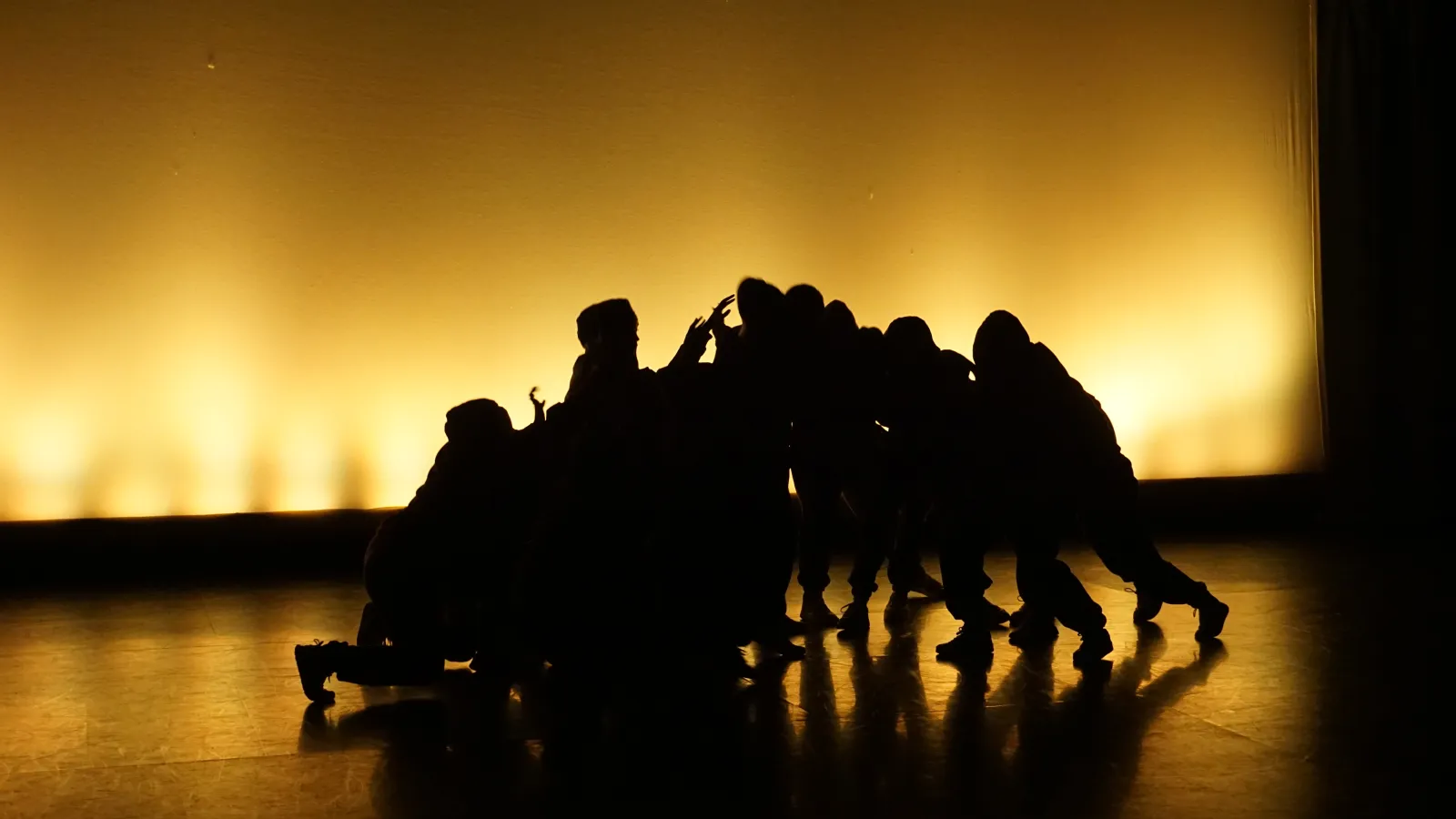 Dancers in front of yellow scrim