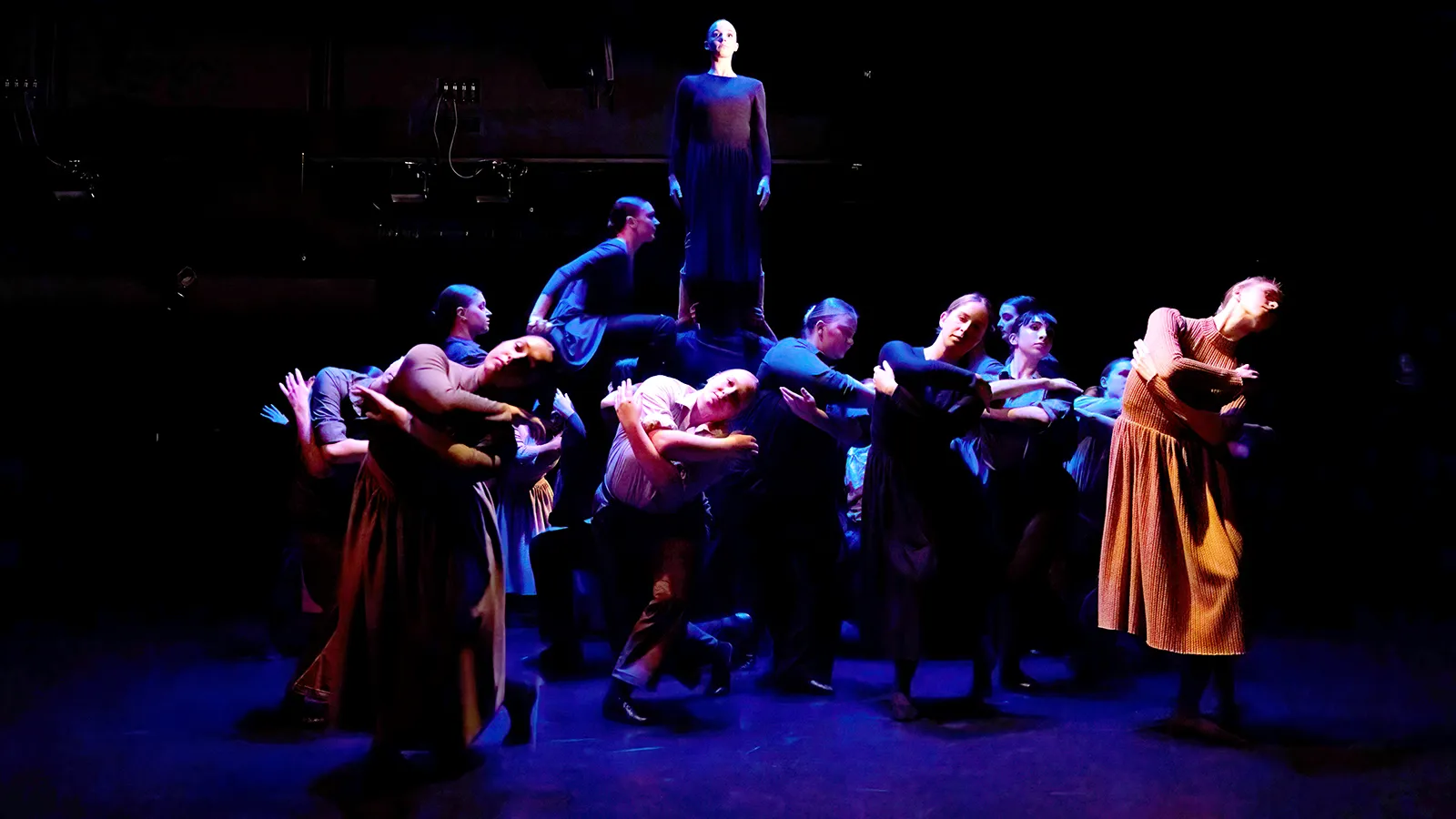 dancers in earth tone costumes on a stage