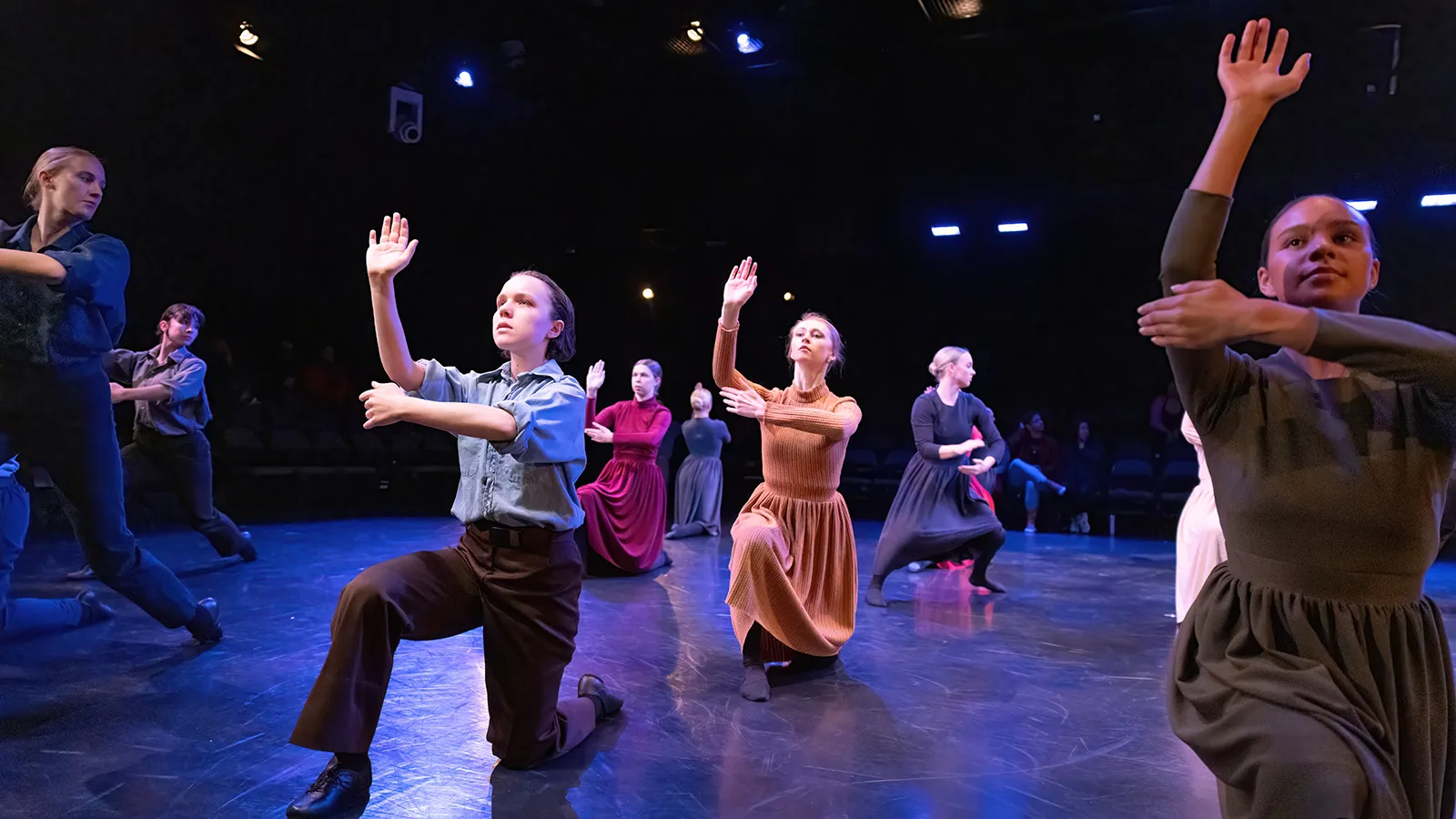 dancers in earth tone costumes on a stage