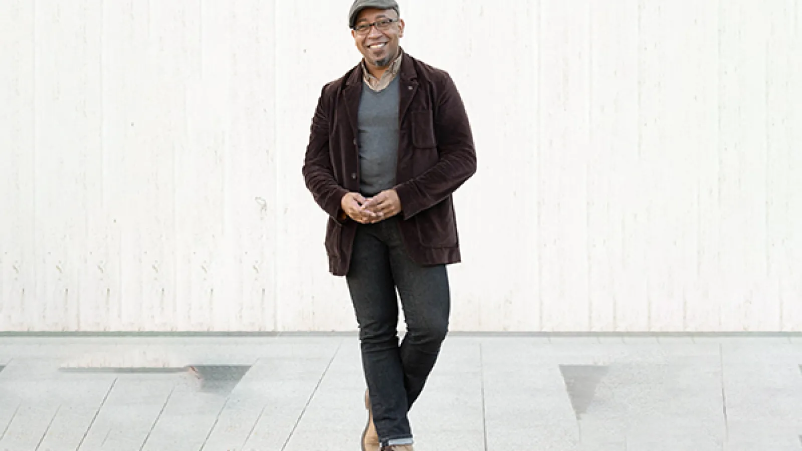 a person wearing a gray hat and brown suit coat