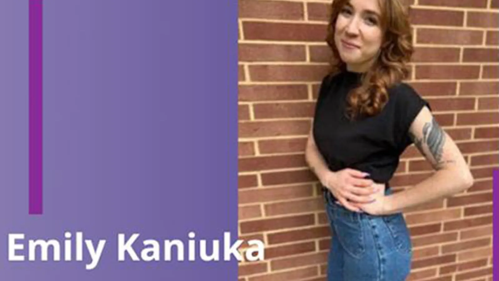 a person with long auburn hair standing in front of brick wall