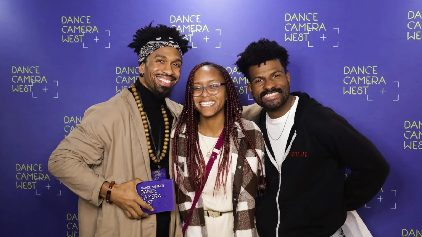 people posing in front of a purple background
