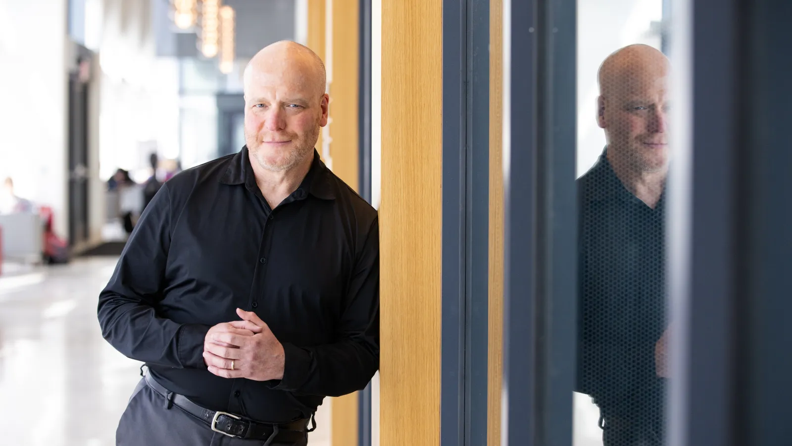 Person wearing a black shirt leaning against a door