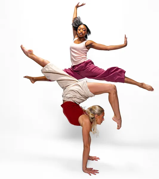 Two dancers performing in front of a white background